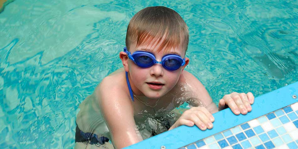 Boy in swim goggles in the pool